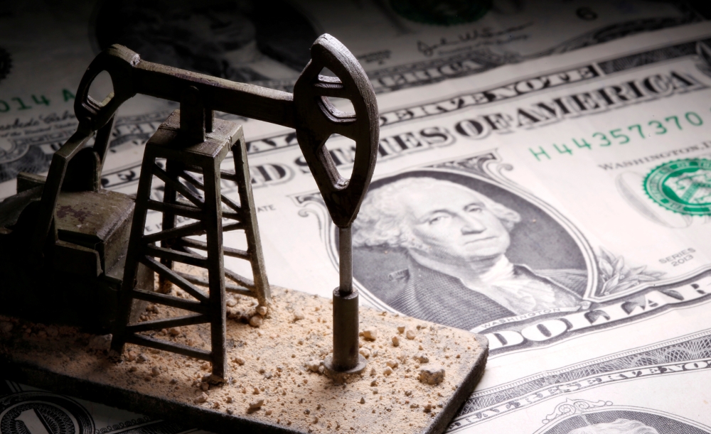A 3D printed oil pump jack is placed on dollar banknotes in this illustration picture. — Reuters