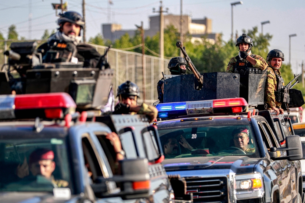 Fighters of Iraq's Hashed al Shaabi paramilitaries move in a convoy during the funeral of Hassan Hammadi al Amiri in Baghdad after he was killed earlier in a US airstrike. - AFP
