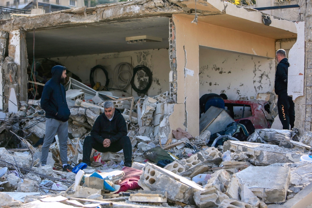 Men check the rubble of a building in Bint Jbeil in southern Lebanon near the border with Israel following Israeli bombardment the previous night. - AFP

