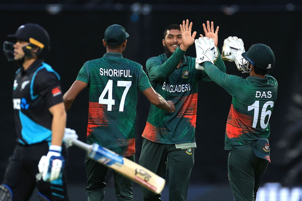New Zealand's Mark Chapman (L) walks from the field as Bangladesh's Rishad Hossain (2nd R) celebrates the wicket with teammates Shoriful Islam (2nd L) and wicketkeeper Litton Das (R) during the first Twenty20 cricket match between New Zealand and Bangladesh at McLean Park in Napier on December 27, 2023. (Photo by Marty MELVILLE / AFP)

