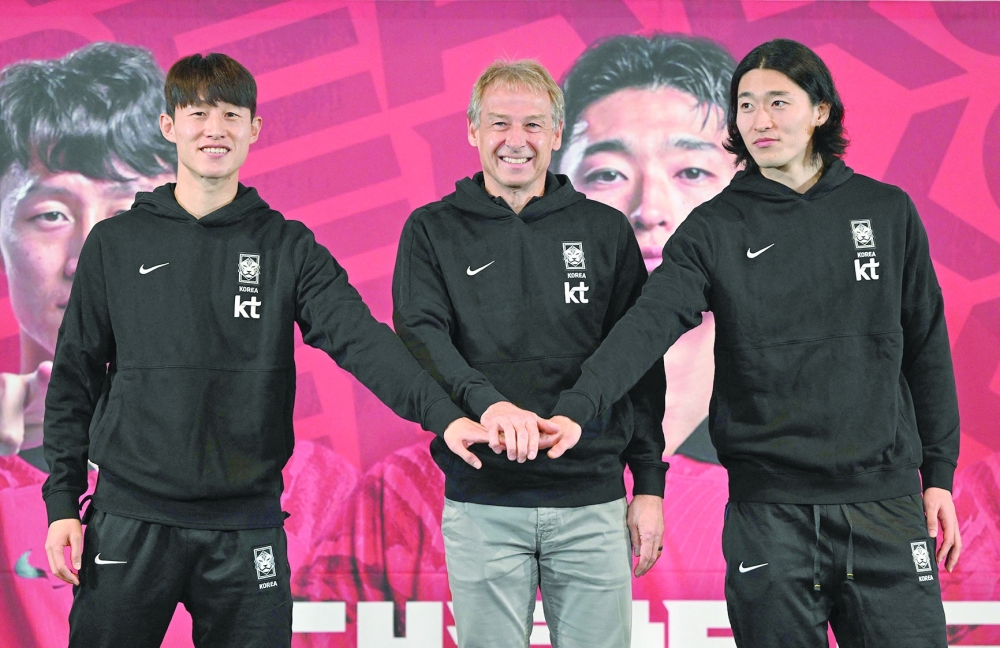 South Korea's national football team head coach Jurgen Klinsmann (C) poses with his players Cho Gue-sung (R) and Lee Jae-sung (L) during a press conference to announce the South Korean squad for the Asian Cup in Seoul on December 28, 2023.  (Photo by Jung Yeon-je / AFP)