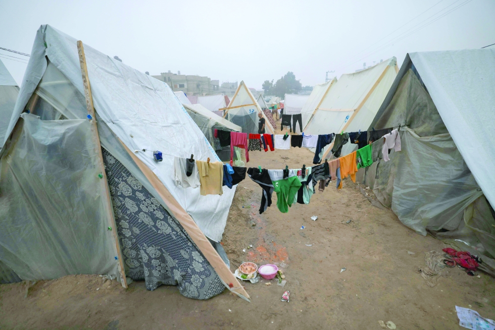 Laundry hangs on makeshift shelters at a camp for displaced Palestinians in Rafah on the southern Gaza strip. — AFP 