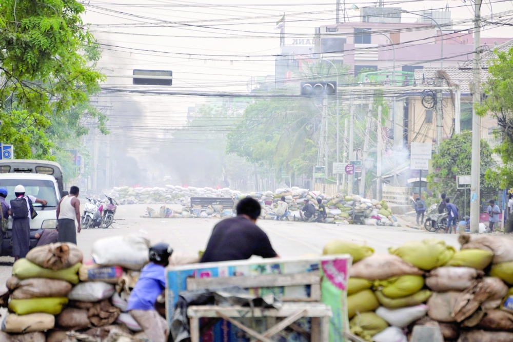 Protesters take cover behind barricades during a demonstration in Mandalay, Myanmar. — Reuters file photo