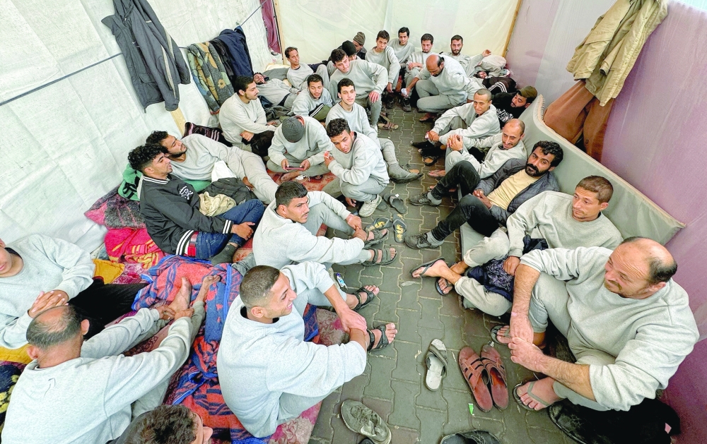 Palestinians who were detained by the Israeli army and said they were ill-treated, gather as they shelter in a school in Rafah, southern Gaza Strip. - Reuters