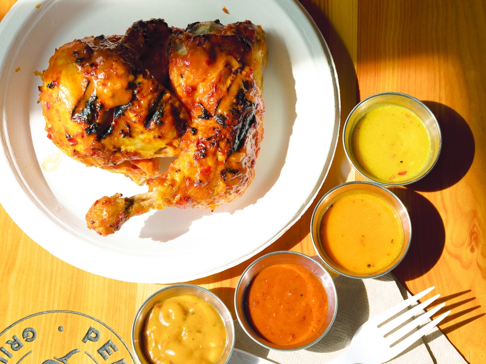 Peri Peri half chicken with house-made hot sauces at Piri Piri Grill House in Brooklyn.