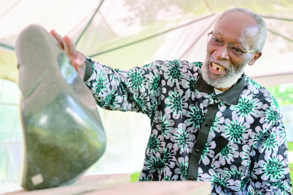 Kenyan sculptor Elkana Ong'esa shows one of his sculptures while mentoring a workshop on stone carving in Tabaka near Kisii. - AFP 