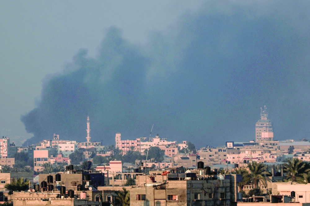 A picture taken from Rafah shows smoke from Israeli bombardment covering the skyline of Khan Yunis in the southern Gaza Strip. - AFP
