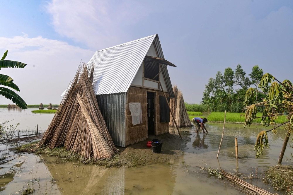 A man works near the 'Khudi Bari' or 'tiny house', a mobile modular shelter, in Char Shildah, Bangladesh. - AFP