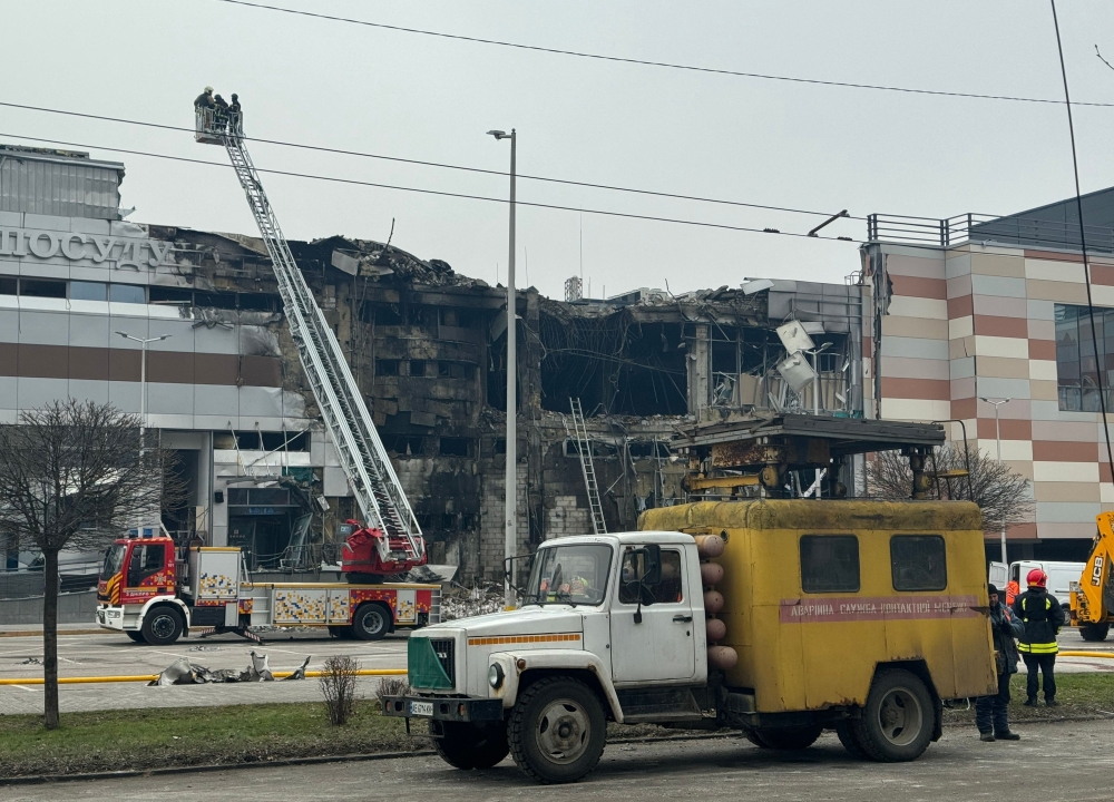 Firefighters and municipal employees work at the site after a rocket attack in the city of Dnipro, Ukraine. — AFP 