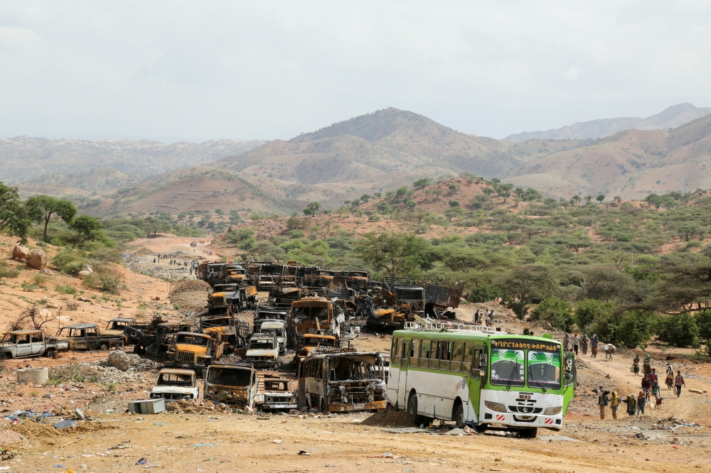 Villagers return from a market to Yechila town walking past scores of burned vehicles, in Tigray, Ethiopia. — Reuters file photo