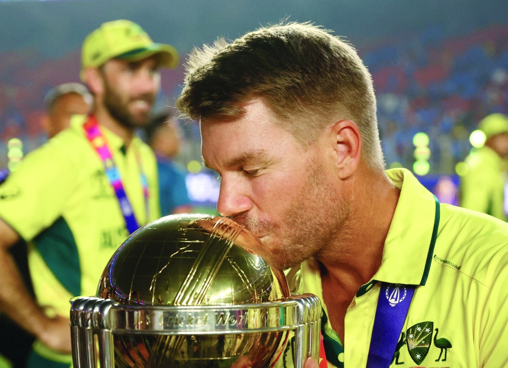 Australia's David Warner celebrates with the trophy after winning the 2023 ICC Cricket World Cup in November. — Reuters