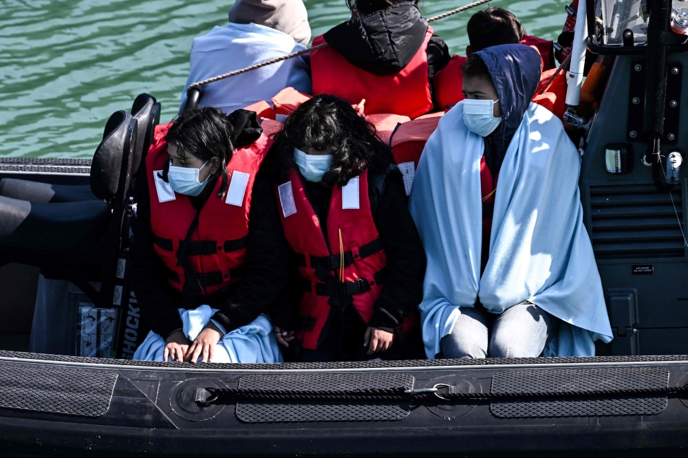 Migrants are seen on the UK Border Force rubber dinghy, after they were picked up at sea while attempting to cross the English Channel and brought to the Marina in Dover. — AFP file photo