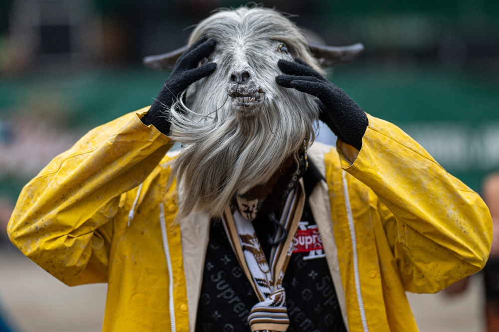 An inhabitant of the province of Chumbivilcas, in Cuzco, southern Peru, wears an animal mask while celebrating Takanakuy (Quechua for "to hit each other") in San Juan de Lurigancho, on the outskirts of Lima, on December 25, 2023. Takanakuy is an annually established practice of dueling fights between community members that combines music, traditional dances, and Christian symbols. (Photo by ERNESTO BENAVIDES / AFP)

