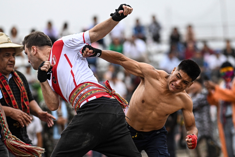 TOPSHOT - Inhabitants of the province of Chumbivilcas, in Cuzco, southern Peru, celebrate Takanakuy (Quechua for "to hit each other") in San Juan de Lurigancho, on the outskirts of Lima, on December 25, 2023. Takanakuy is an annually established practice of dueling fights between community members that combines music, traditional dances, and Christian symbols. (Photo by ERNESTO BENAVIDES / AFP)

