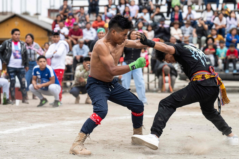 Inhabitants of the province of Chumbivilcas, in Cuzco, southern Peru, celebrate Takanakuy (Quechua for "to hit each other") in San Juan de Lurigancho, on the outskirts of Lima, on December 25, 2023. Takanakuy is an annually established practice of dueling fights between community members that combines music, traditional dances, and Christian symbols. (Photo by ERNESTO BENAVIDES / AFP)

