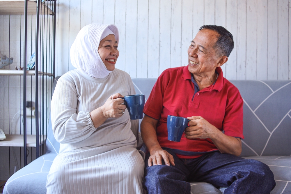 Happy,Mature,Husband,And,Wife,Sit,Rest,On,Comfortable,Sofa