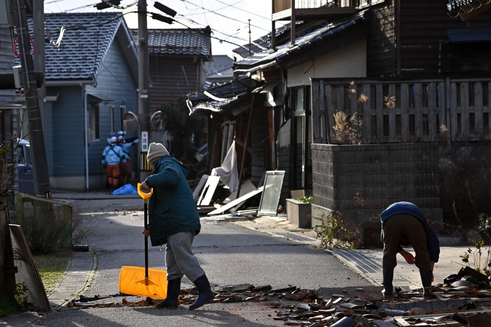 Residents clean up debris in Wajima, Ishikawa prefecture on Tuesday, a day after a major 7.5 magnitude earthquake struck the Noto region in Ishikawa prefecture in the afternoon. - AFP