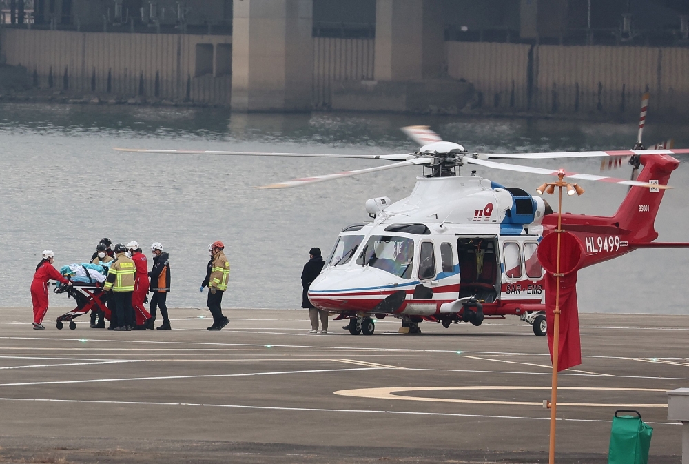 South Korean opposition party leader Lee Jae-myung gets off from a helicopter on a stretcher to be transported to Seoul National University Hospital. — AFP 