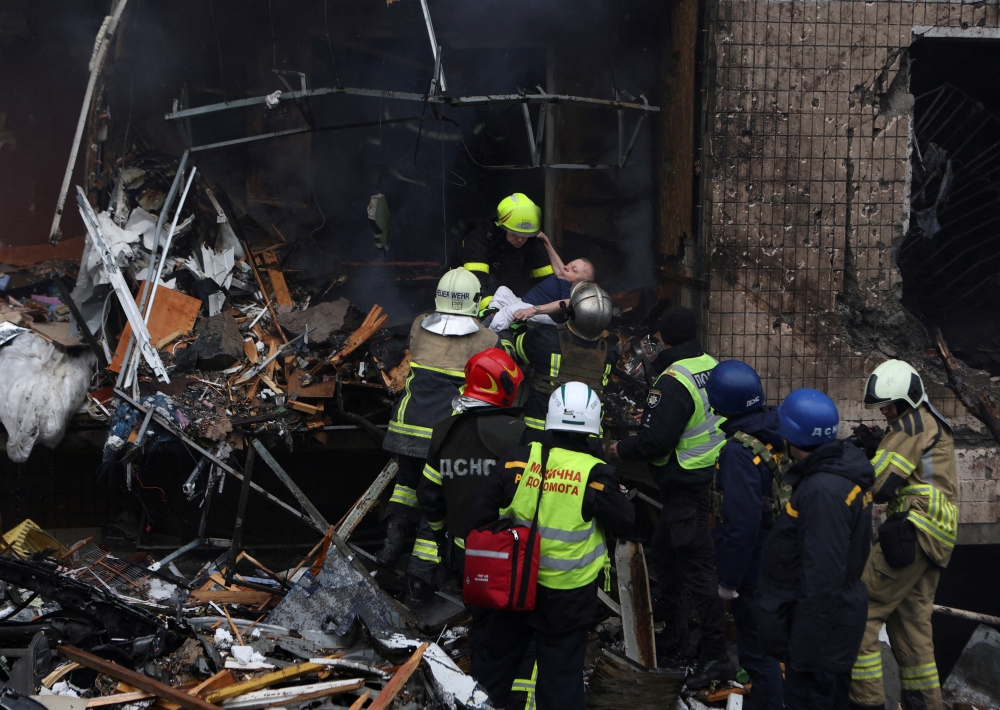 Rescuers evacuate a local resident from a residential building heavily damaged during a Russian missile attack, in Kyiv, Ukraine. — Reuters 