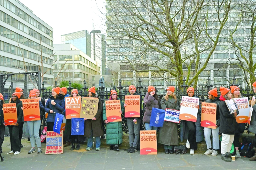 People hold British Medical Association (BMA) branded placards calling for better pay, as they stand on a picket line outside St Thomas’ Hospital in central London. — AFP