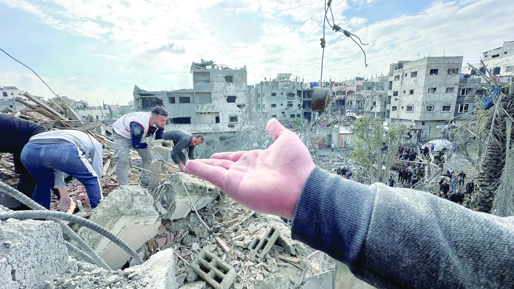 Palestinians inspect the site of an Israeli strike on a house in Jabalia in the northern Gaza Strip. - Reuters
