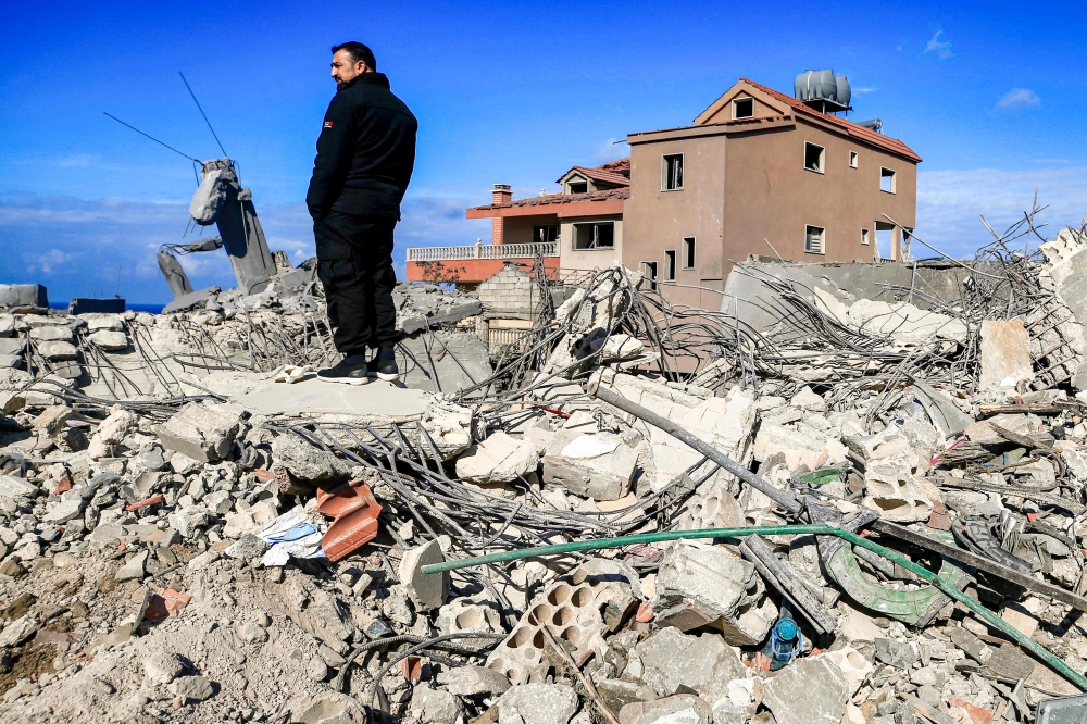 A man stands amidst the rubble of destroyed buildings following strikes on the the town of Naqura in southern Lebanon close to the border with northern Israel on Thursday. — AFP