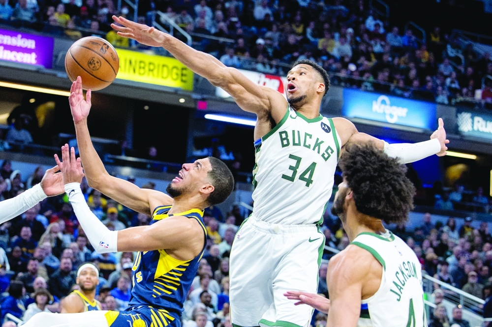 Indianapolis, Indiana, USA; Indiana Pacers guard Tyrese Haliburton (0) shoots the ball while Milwaukee Bucks forward Giannis Antetokounmpo (34) defends in the second half at Gainbridge Fieldhouse. Mandatory Credit: Trevor Ruszkowski-USA TODAY Sports