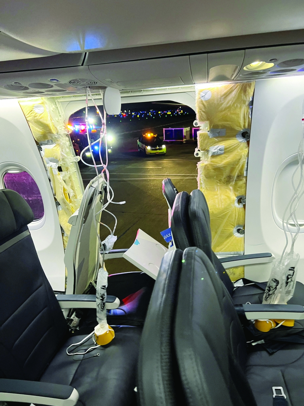 Passenger oxygen masks hang from the roof next to a missing window and a portion of a side wall of an Alaska Airlines Flight 1282, in Portland, Oregon, US. — Reuters