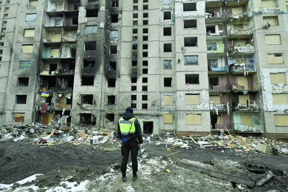 A policeman stands in front of a heavily damaged residential building, three days after a Russian missile attack in Kyiv. — AFP