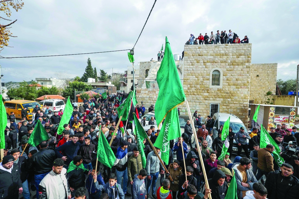 Palestinians march along a street in Arura, in the occupied West Bank. — AFP 