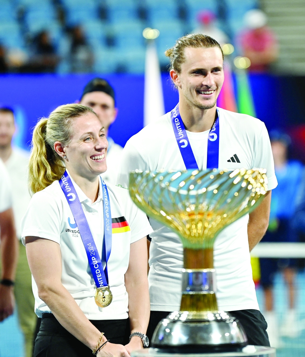 Alexander Zverev and Angelique Kerber pose with the trophy. — REUTERS