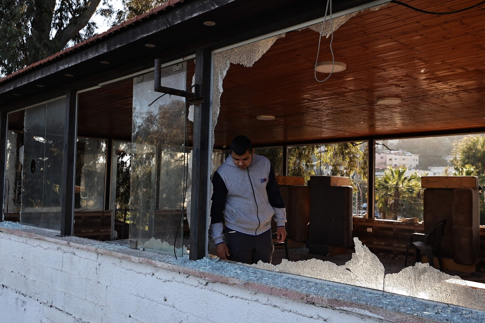 A man checks the damage in a building following an Israeli raid in Jenin in the occupied West Bank. — AFP 