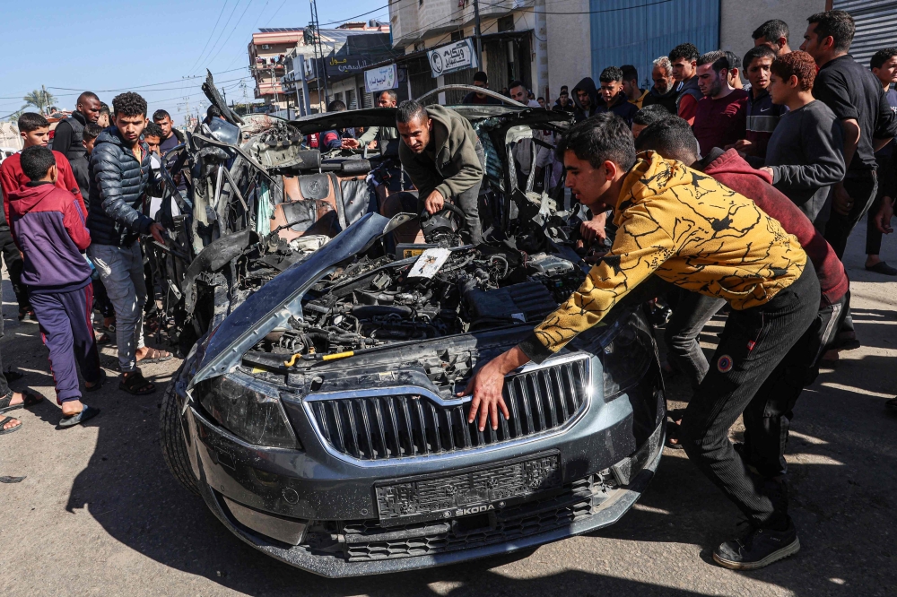 People check the car in which two journalists,Mustafa Thuria and Hamza Wael Dahdouh were killed in a reported Israeli strike in Rafah. — AFP 