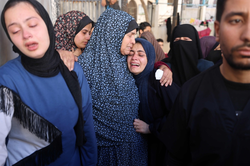 The widow (C-R) is supported by a relative during the funeral of her husband, who was killed in a reported Israeli air strike in Rafah. — AFP 