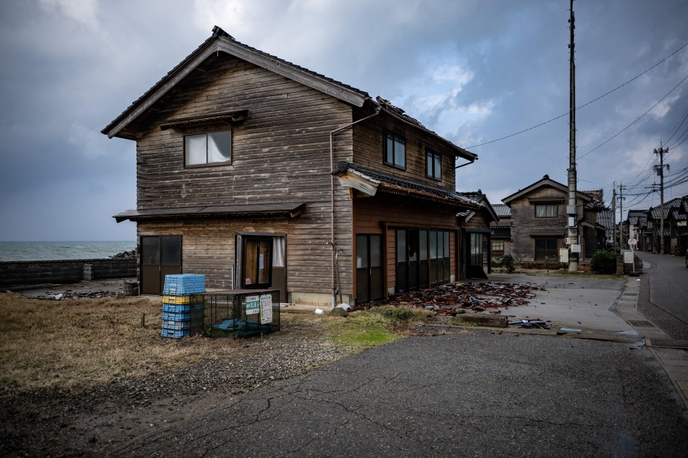 This picture taken on January 6, 2024 shows houses in Akasaki village, Ishikawa prefecture after a major 7.5 magnitude earthquake struck the Noto region on New Year's Day. Wooden buildings across Japan's Noto Peninsula were demolished by a massive earthquake on New Year's Day, but thanks to a quirk of architecture, one small fishing village stood strong.