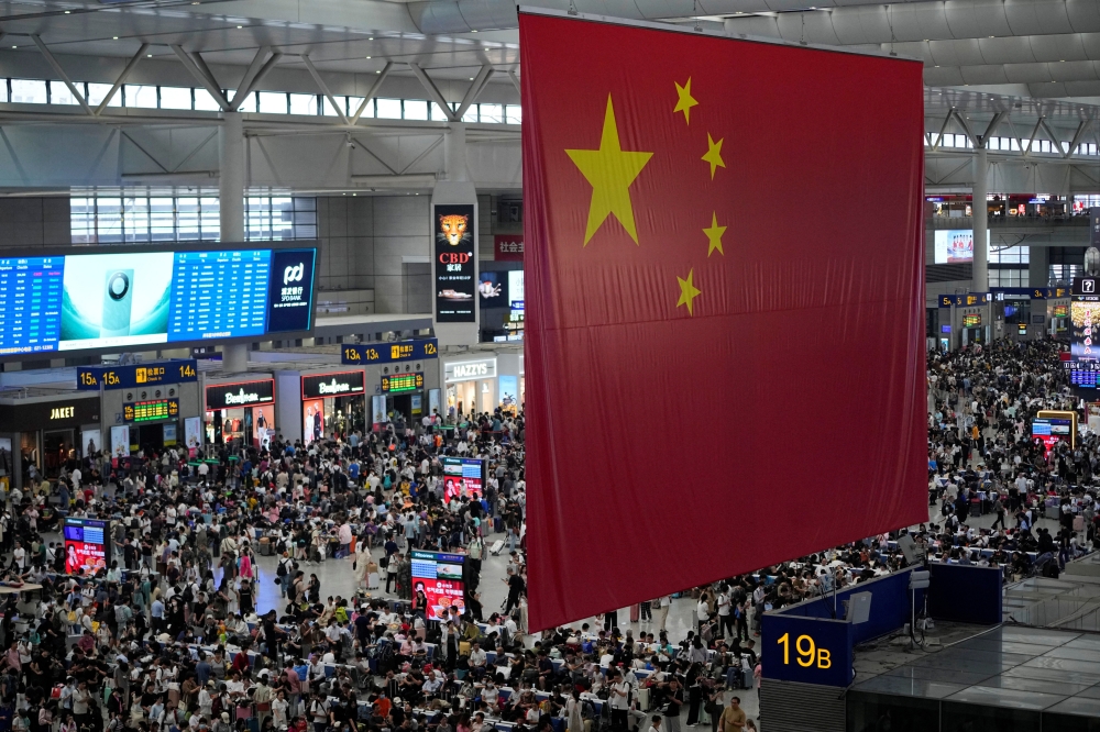 People wait to board trains at the Shanghai Hongqiao railway station ahead of the National Day holiday, in Shanghai, China. — Reuters