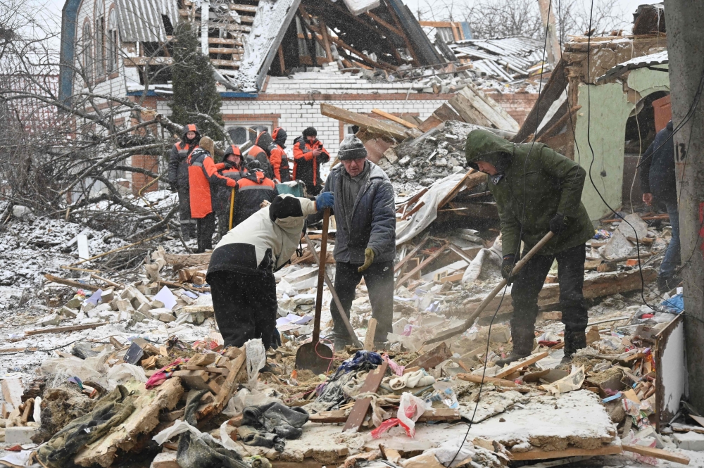 Rescuers and local residents clear debris following Russian strikes, in Zmiiv, Kharkiv region. — AFP 