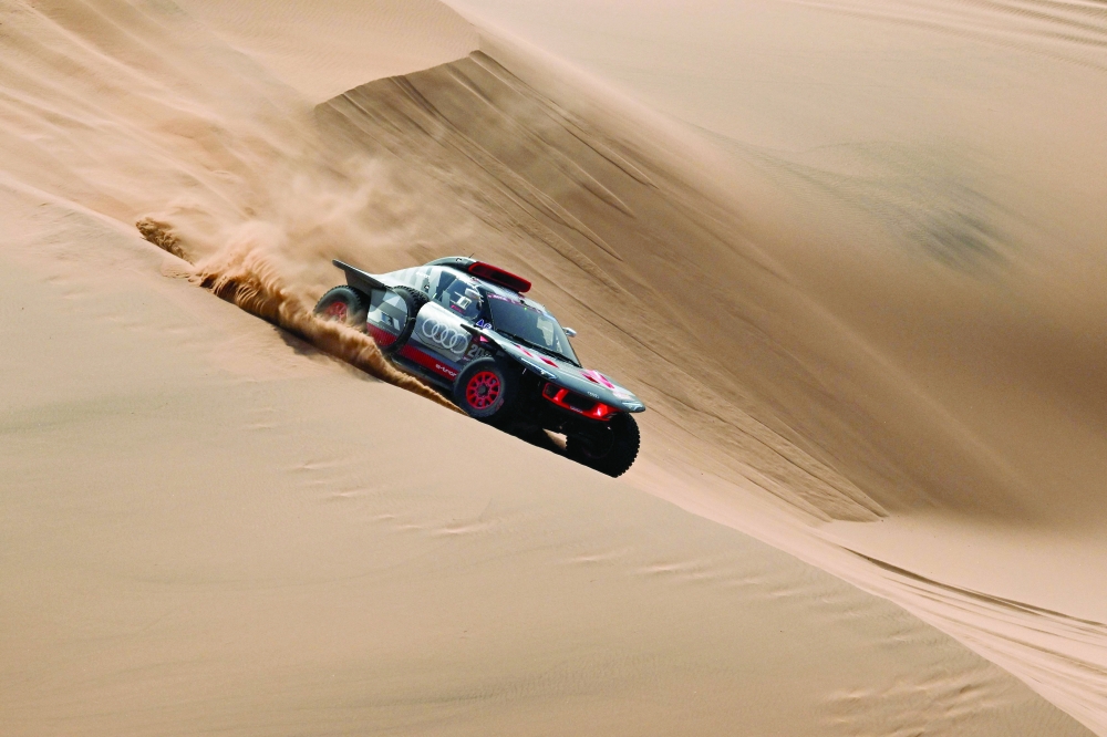 Team Audi Sport's French driver Stephane Peterhansel and his French co-driver Edouard Boulanger steer their car during stage 2 between Al Henakiyah and Al Duwadimi, Saudi Arabia, on January 7, 2024, as part of the Dakar rally 2024. (Photo by PATRICK HERTZOG / AFP)