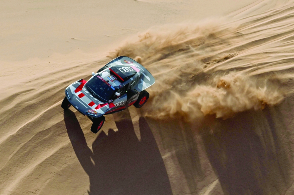 Team Audi Sport's French driver Stephane Peterhansel and his French co-driver Edouard Boulanger steer their car during stage 2 between Al Henakiyah and Al Duwadimi, Saudi Arabia, on January 7, 2024, as part of the Dakar rally 2024. (Photo by PATRICK HERTZOG / AFP)