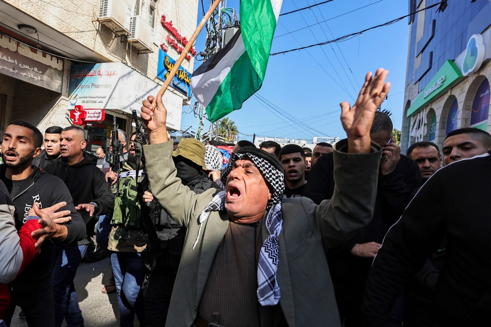 Palestinians shout slogans during the funeral of three men killed during an overnight Israeli raid on the Tulkarem refugee camp in the occupied West Bank. — AFP 