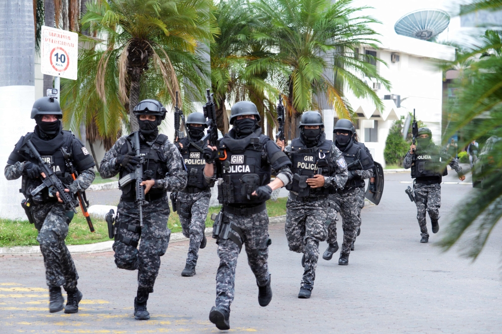 An Ecuadorean police squad enters the premises of Ecuador's TC television channel after unidentified gunmen burst into the state-owned television studio live on air, in Guayaquil, Ecuador. — AFP