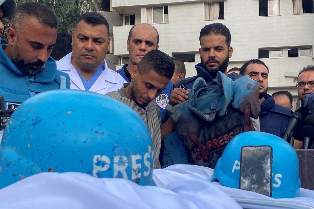 Colleagues of Palestinian journalists Mohammed Soboh and Saeed al-Taweel, who were killed when an Israeli missile, stand next to their bodies at a hospital in Gaza.