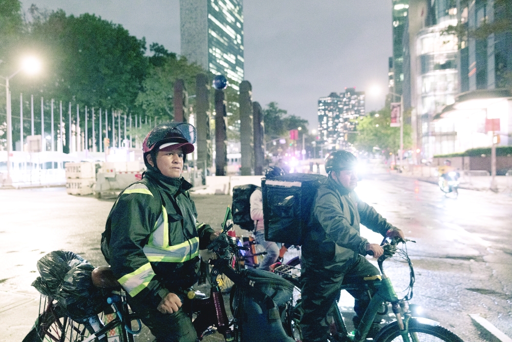 Sergio Solano, left, and another food delivery worker on their bicycles in Manhattan.