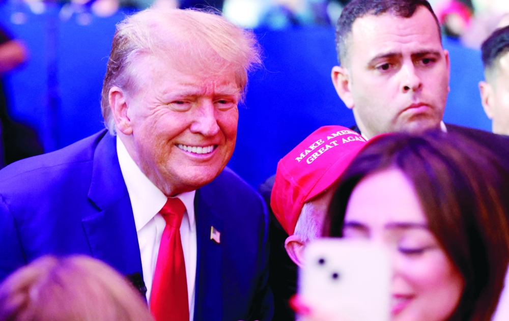 Former US President and 2024 Republican presidential hopeful Donald Trump greets supporters as he leaves a town hall in Des Moines, Iowa. - AFP

