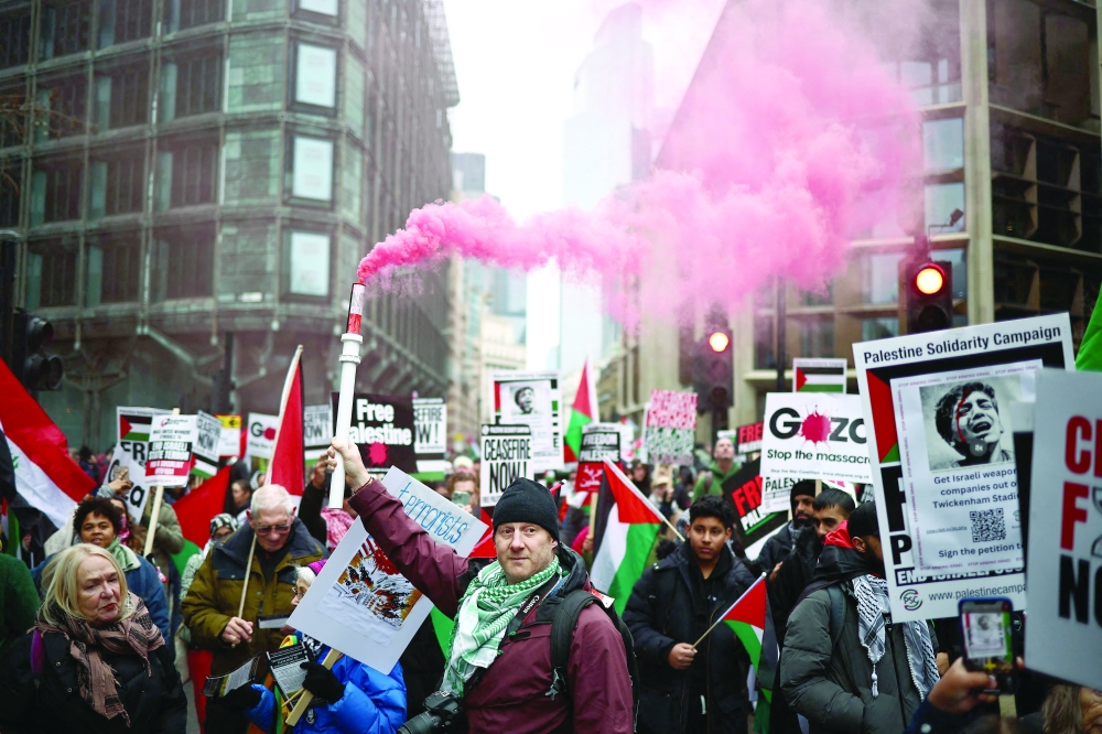 Pro-Palestinian activists and supporters wave flags and carry placards during a National March for Palestine in central London. — AFP