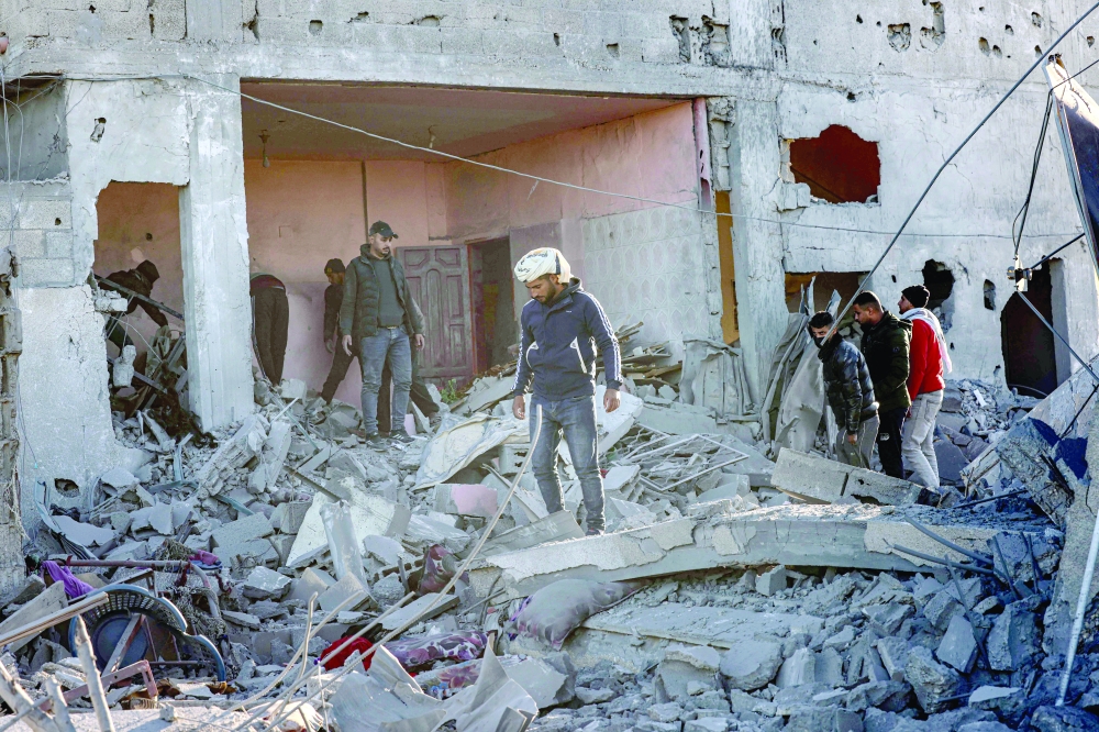 People inspect the damage following Israeli bombardment in Rafah in the southern Gaza Strip. — AFP