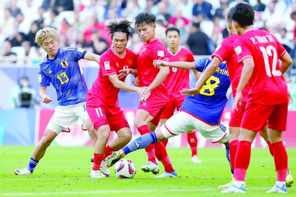 Japan's midfielders #08 Takumi Minamino and #13 Keito Nakamura fight for the ball with Vietnam's midfielder #11 Nguyen Tuan Anh during the Qatar 2023 AFC Asian Cup Group D football match between Japan and Vietnam at the Al-Thumama Stadium in Doha. AFP