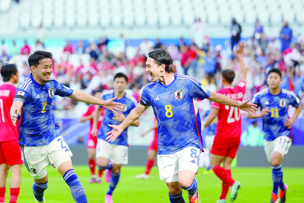Japan's midfielder #08 Takumi Minamino celebrates after scoring his team's first goal during the Qatar 2023 AFC Asian Cup Group D football match between Japan and Vietnam at the Al-Thumama Stadium in Doha on January 14, 2024. AFP