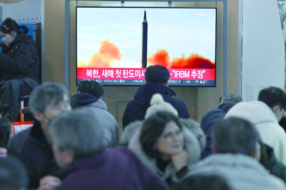 People watch a television screen showing a news broadcast with file footage of a North Korean missile test, at a railway station in Seoul. — AFP
