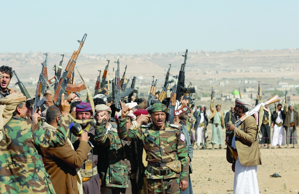 Yemeni fighters and tribal supporters hold up their firearms during a protest against recent U.S.-led strikes on Houthi targets, near Sanaa. — Reuters 